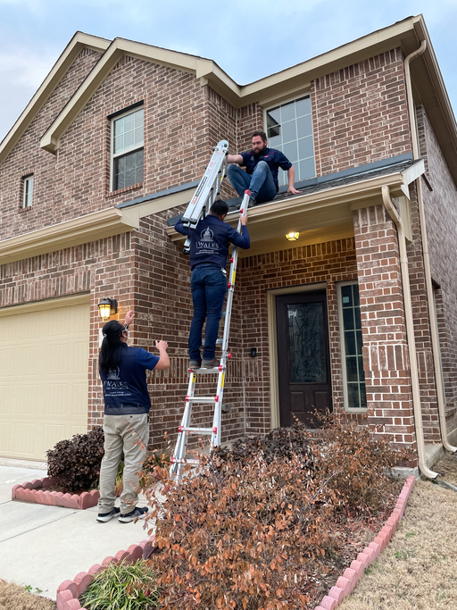 Mckinney, TX USA - March 1, 2021: Roof inspector climbing up to the roof to check the damage after a hail
