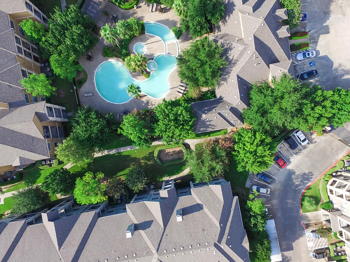 Aerial view of an apartment complex with a pool Aerial view of an apartment complex with a pool