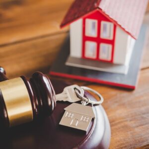 Miniature house, keys, and a gavel. 