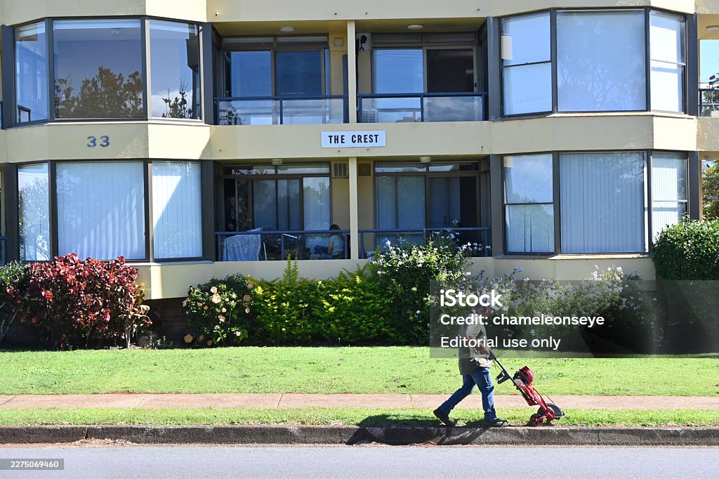 Port Macquarie, Nsw - Apr 27 2026:Landscaper cutting lawn edge with wheel edge cutter tool.A wheel edge cutter (or manual rotary edger) is a simple, effective tool for maintaining clean, professional lines between your lawn and hard surfaces like sidewalks, driveways, or garden beds.