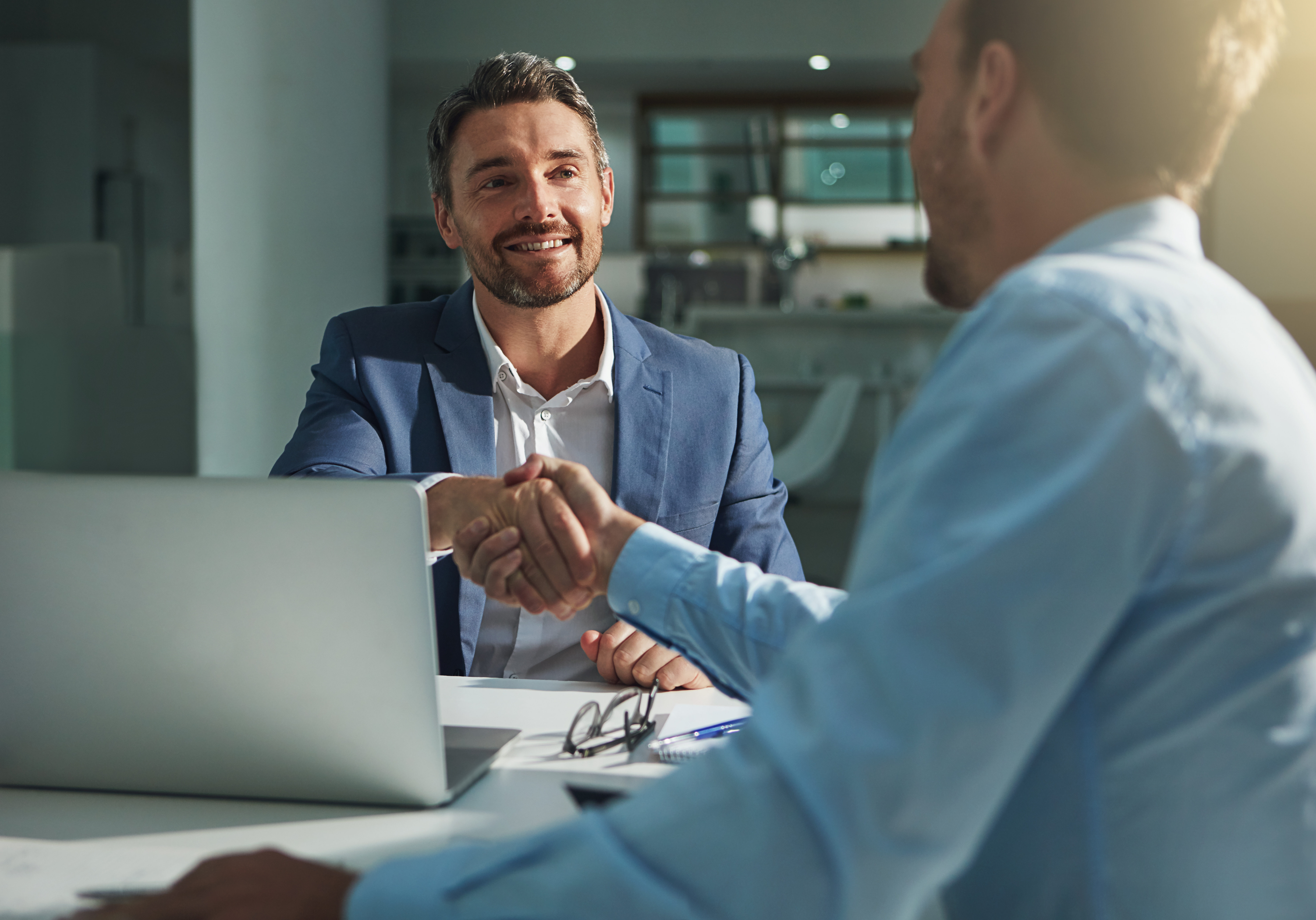 Shot of two businessmen shaking hands in an office